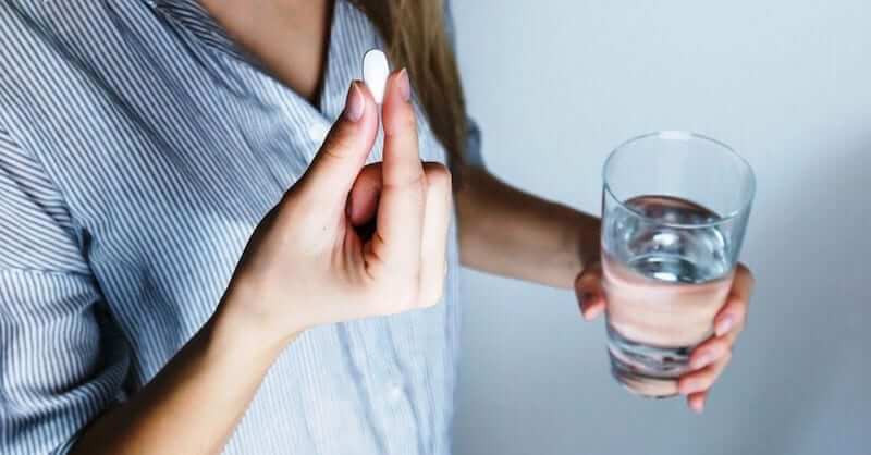 Woman taking a pain relief tablet