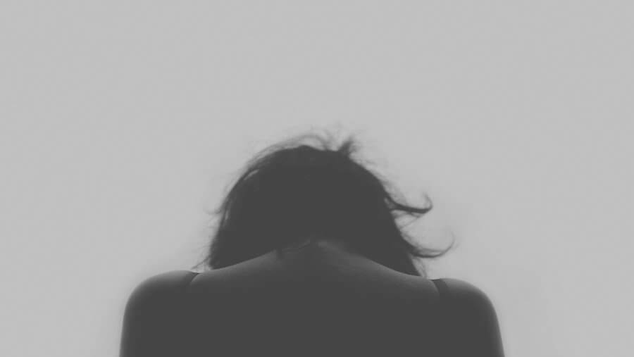Woman who has suffered trauma, seen from behind